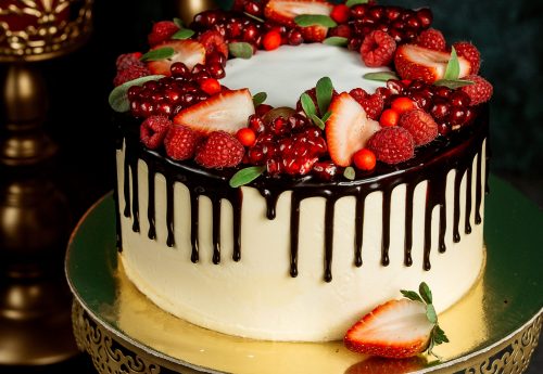 chocolate drip cake with white cake garnished with berries